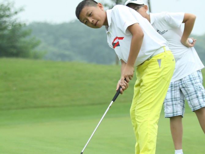 绿茵挥杆献爱心 父子同心展英姿